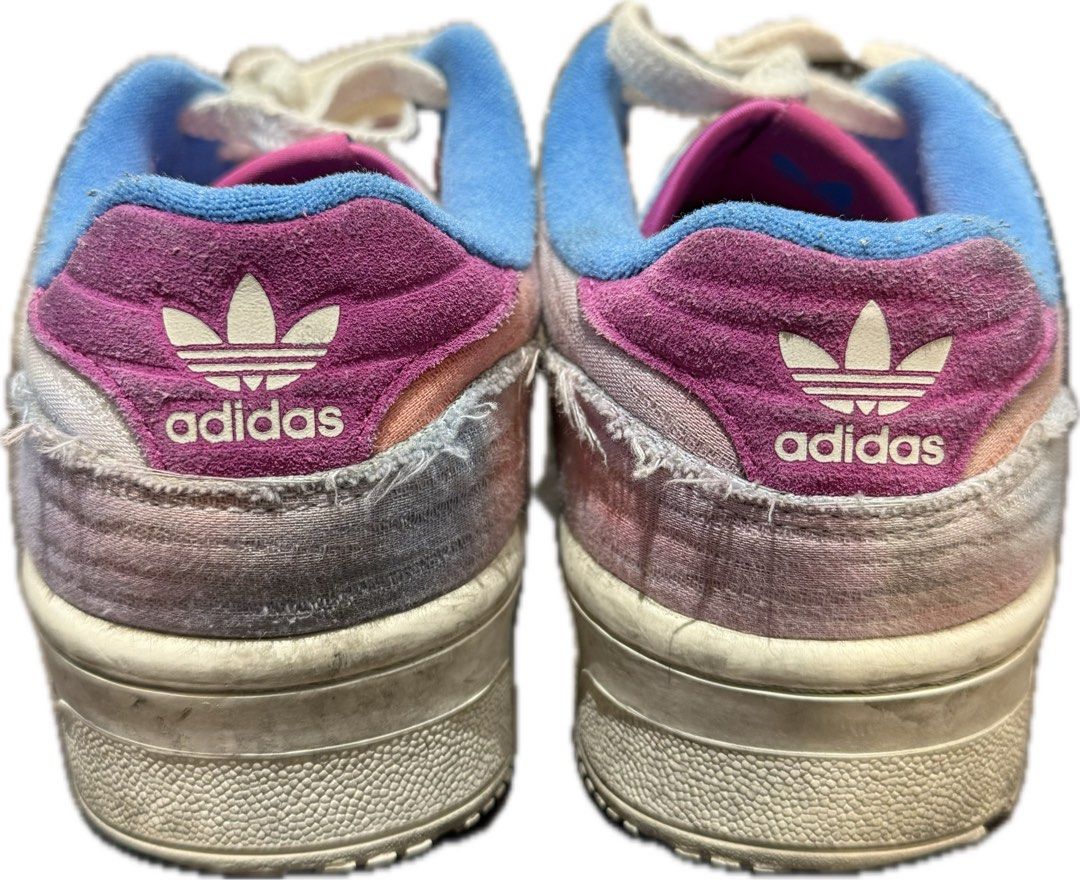 Adidas Rivalry Low Tie-Dye Sneakers (Category: Sneakers) located in Pasig City. Submitted by thisisfnjoy (Listing ID 1448890252, Image 2). Description: - Adidas Rivalry Low sneakers -Size 11 -8/10 only needs cleaning -Soles still good and thick - Unique tie-dye pattern - Blue Adidas stripes - Pink/purple heel accents - Distinctive frayed fabric edges - White laces - Ideal for casual wear.
