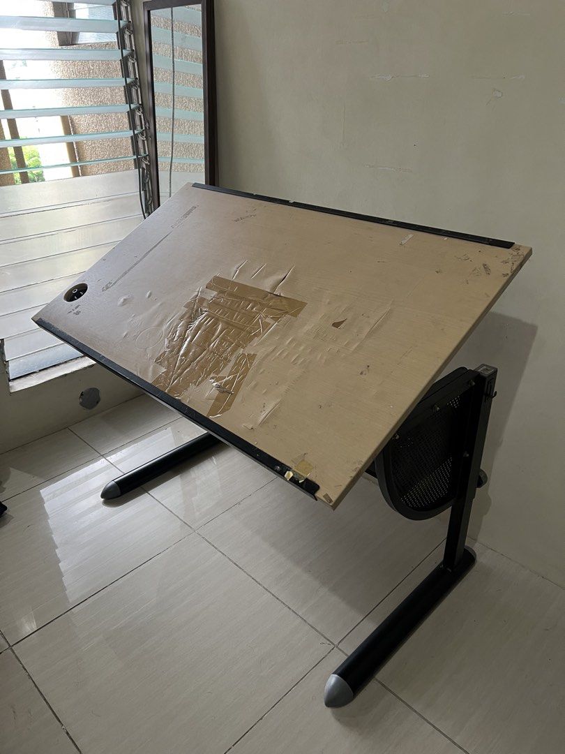 Adjustable Drafting Table Art Desk (Category: Tables & Sets) located in Cebu City. Submitted by rap.declutter (Listing ID 1448795706, Image 1). Description: RFS: moving out - Adjustable drafting table, perfect for drawing, sketching, and art projects. - Surface tilts to multiple angles for comfortable use. - Sturdy legs ensure excellent support and stability. INCLUDES: 5 backing papers (cartolina) 9 tracing papers 2 rotring paper cases 3 t square