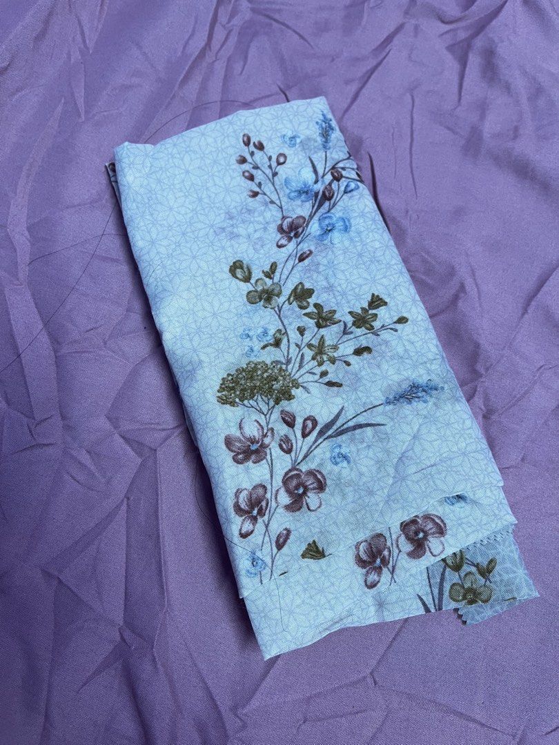 bawal for kids (Category: Hijabs) located in Kuala Lumpur. Submitted by nureykha (Listing ID 1448878183, Image 1). Description: - Light blue fabric with a delicate floral print - Subtle geometric pattern in the background - Flowers in shades of blue, brown, and green - Ideal for sewing projects and crafts.