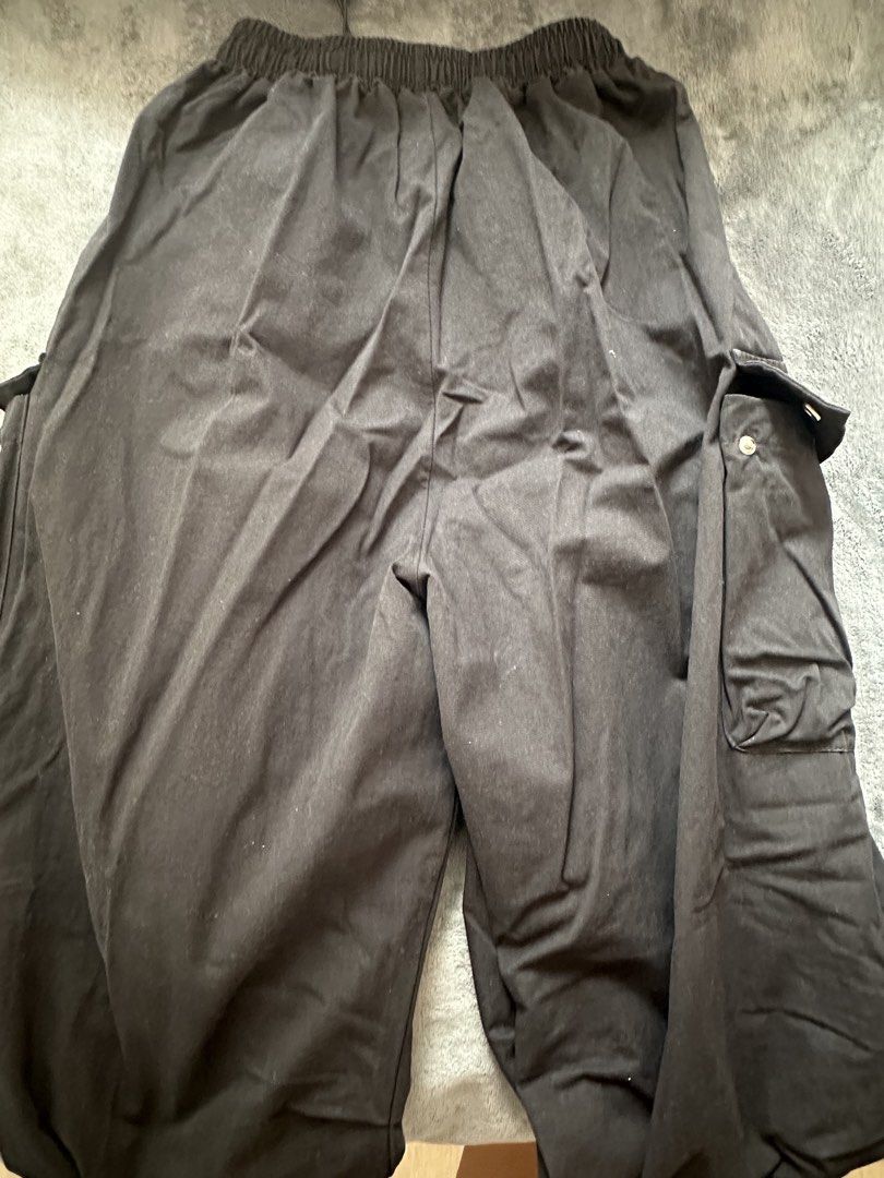 Black Cargo Pants with Drawstrings and Pockets (Category: Other Bottoms) located in Taguig. Submitted by stigmapanda (Listing ID 1448846553, Image 2). Description: - Classic black cargo pants - Comfortable elastic waistband with adjustable drawstring - Multiple practical side pockets - Adjustable drawstring at the ankle for a customized fit - Measurements: Waist 31 cm, Hip 33 cm, Length 103 cm - Ideal for everyday casual wear.