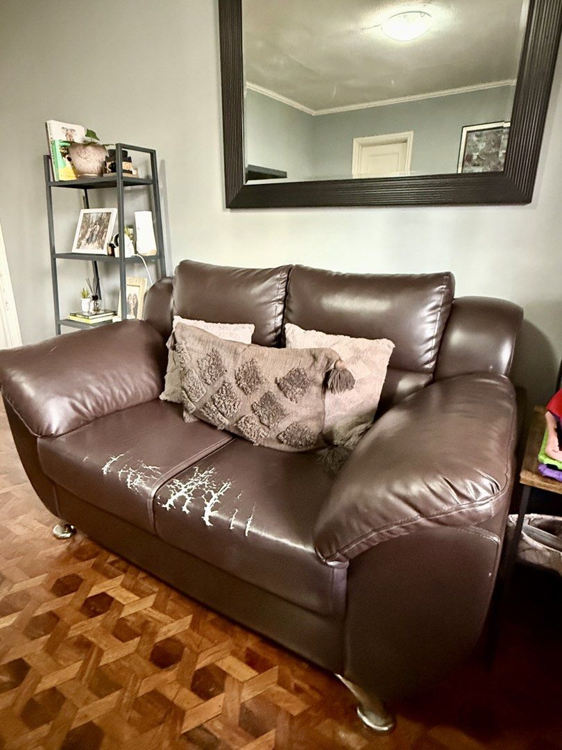 Brown Faux Leather 2-Seater Sofa (Category: Sofas) located in Manila. Submitted by freakath1297335 (Listing ID 1448818007, Image 2). Description: - Modern brown faux leather 2-seater sofa - Sleek metal legs - Some wear and tear on seat cushions (as pictured) - Comes with two decorative throw pillows - Ideal for smaller living spaces.