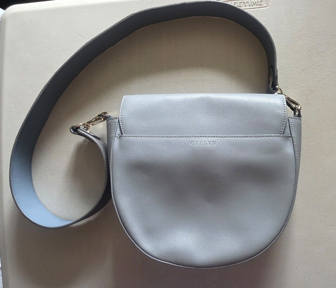 CARLYN Light Blue Leather Saddle Bag with Studs (Category: Cross-body Bags) located in Manila. Submitted by oliviajanuari (Listing ID 1448700464, Image 2). Description: CARLYN Light Blue Leather Saddle Bag with Studs - Color: Light Blue - Style: Saddle Bag - Details: Silver stud embellishments on front flap - Strap: Grey with light blue underside - Closure: Magnetic - Interior: 1 zipped pocket, 1 slip pocket - Perfect for: Everyday use Location: 