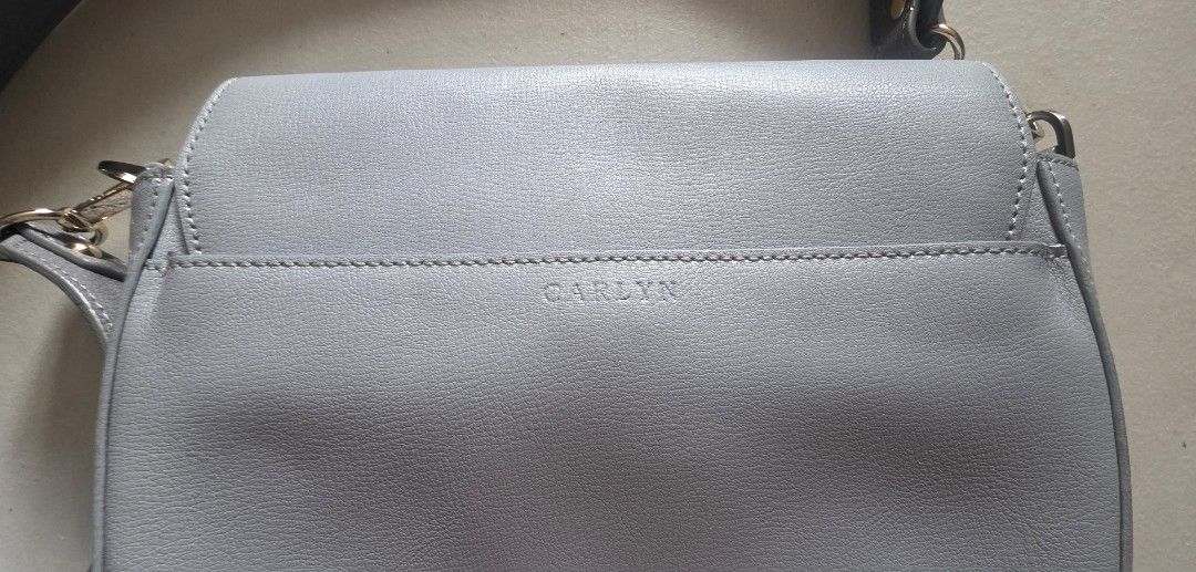 CARLYN Light Blue Leather Saddle Bag with Studs (Category: Cross-body Bags) located in Manila. Submitted by oliviajanuari (Listing ID 1448700464, Image 3). Description: CARLYN Light Blue Leather Saddle Bag with Studs - Color: Light Blue - Style: Saddle Bag - Details: Silver stud embellishments on front flap - Strap: Grey with light blue underside - Closure: Magnetic - Interior: 1 zipped pocket, 1 slip pocket - Perfect for: Everyday use Location: 