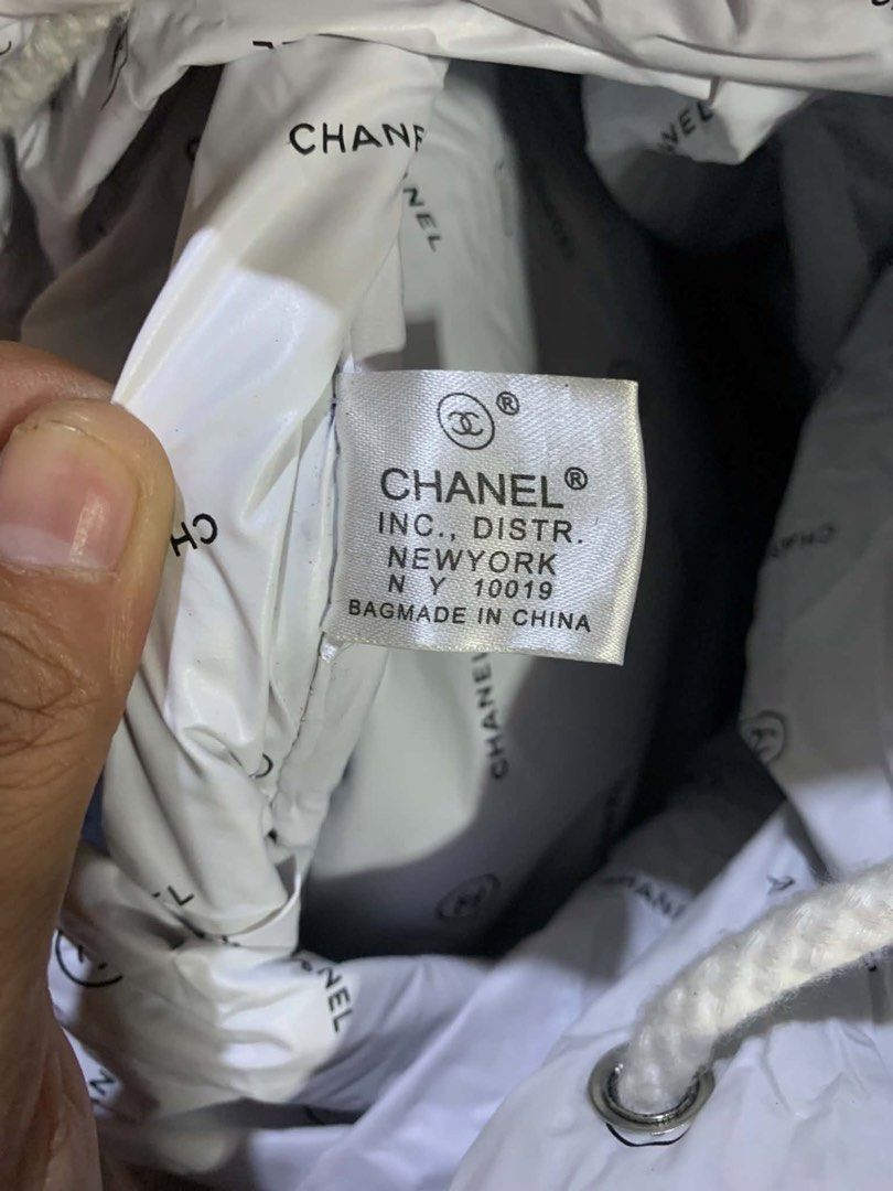 Chanel Black Canvas Drawstring Bucket Bag (Category: Luxury Bags & Wallets) located in Tagum. Submitted by knilevinc69480 (Listing ID 1448824094, Image 3). Description: - Authentic Chanel Black Canvas Drawstring Bucket Bag - White interior lining with repeating Chanel logo pattern - Comfortable rope handles - Made in China - Dimensions: Approximately 13.5 inches tall, 15.5 inches in width.