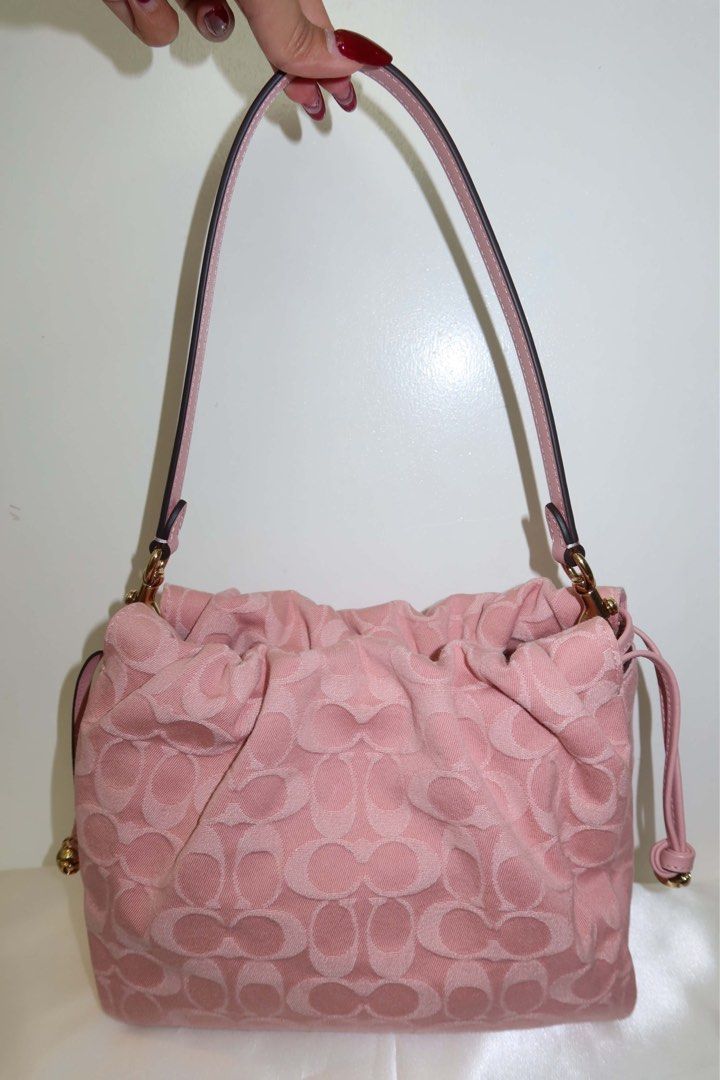 Coach Faye Pink denim (Category: Cross-body Bags) located in Santiago. Submitted by dobongsoon (Listing ID 1448789575, Image 3). Description: - Cute pink Coach bag - Signature C monogram pattern - Drawstring closure - Adjustable strap - Small Coach hang tag - Gold hardware details - Great for everyday use.