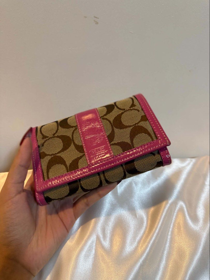 Coach Pink Patent Leather Bifold Wallet (Category: Purses & Pouches) located in Santiago. Submitted by dobongsoon (Listing ID 1448753291, Image 2). Description: - Pink patent leather Coach wallet - Bifold style with snap closure - Multiple card slots - Zippered coin pocket - Pink interior.