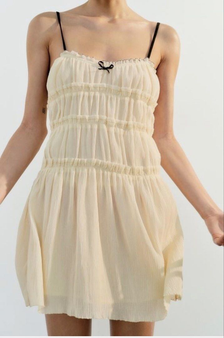 Cream Ruched Mini Dress with Black Straps (Category: Dresses) located in Makati City. Submitted by g.ang.s (Listing ID 1442474842, Image 1). Description: - Cream colored mini dress - Ruched detailing on bodice - Gathered waist - Thin black spaghetti straps with small black bow at bust - Lightweight and flowy fabric - Versatile for casual outings or nights out.