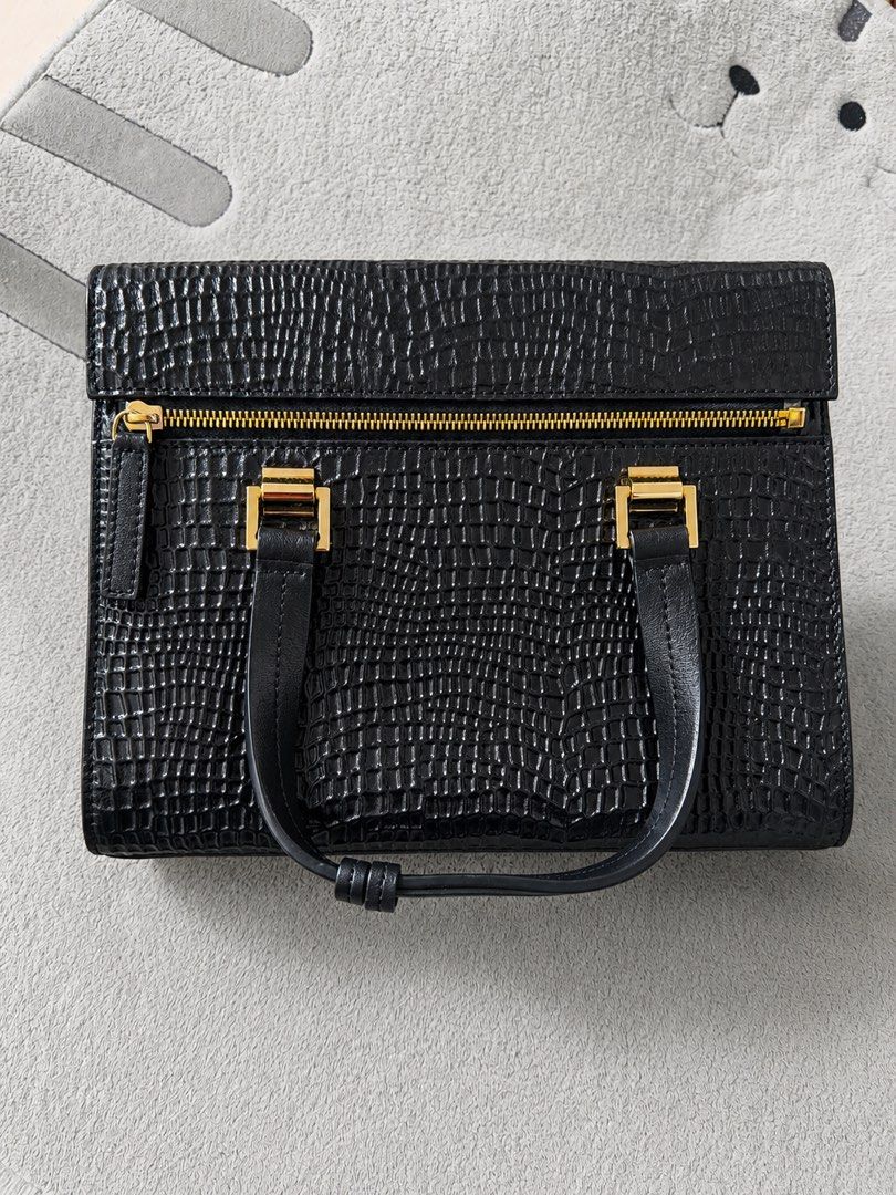 Daniel Hechter Black Croc Embossed Handbag with Gold Hardware (Category: Luxury Bags & Wallets) located in Manila. Submitted by moobrava (Listing ID 1448888536, Image 1). Description: - Elegant black handbag with luxurious croc-embossed texture. - Stylish gold zipper and hardware details. - Multiple interior compartments for organized storage. - Includes a convenient zip pocket inside. - Comes with a detachable shoulder strap for versatile wear. 