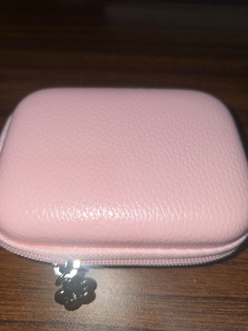 Digicam/Camera Leather Zippered Storage Case (Category: Other Accessories) located in Manila. Submitted by nammie968 (Listing ID 1448836011, Image 2). Description: - Adorable pink storage case with a textured faux leather exterior. - Secure zipper closure adorned with a cute flower-shaped charm. - Interior features elastic straps on one side for secure storage. - Includes a convenient mesh pocket on the other side for visibility. - Perfect for or