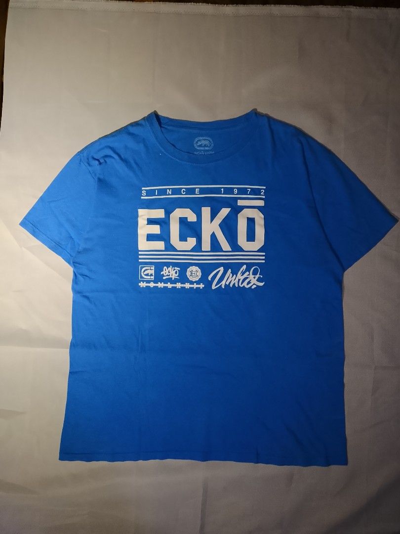 Ecko Unltd. Blue Graphic T-Shirt (Category: Tshirts & Polo Shirts ) located in Muntinlupa City. Submitted by jo_thrift2 (Listing ID 1448894144, Image 1). Description: - Blue Ecko Unltd. graphic t-shirt - Features iconic Ecko logo and 'Since 1972' text - Size: Large (L) - Perfect for everyday casual wear.