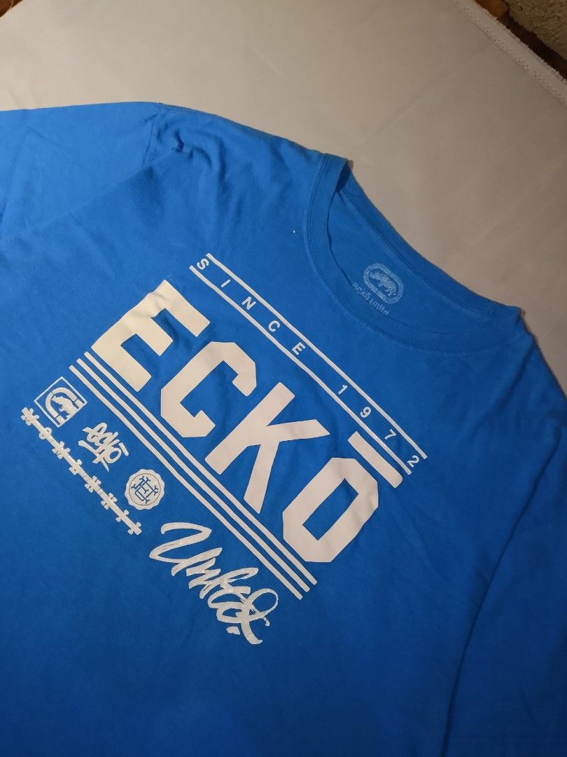 Ecko Unltd. Blue Graphic T-Shirt (Category: Tshirts & Polo Shirts ) located in Muntinlupa City. Submitted by jo_thrift2 (Listing ID 1448894144, Image 2). Description: - Blue Ecko Unltd. graphic t-shirt - Features iconic Ecko logo and 'Since 1972' text - Size: Large (L) - Perfect for everyday casual wear.