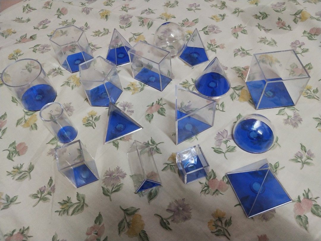 Educational Geometric Solids Set - Clear Plastic & Blue Base (Category: Educational & Learning Toys) located in Manila. Submitted by olap.santos (Listing ID 1448831838, Image 2). Description: - Set of clear plastic geometric shapes with blue bases. - Includes: cubes, prisms, pyramids, cylinders, and spheres. - Ideal for learning geometry concepts. - All pieces are in their original box compartments. - Some pieces have a small blue dot on the insi
