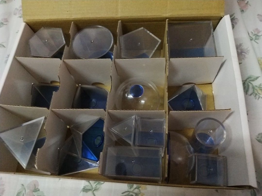 Educational Geometric Solids Set - Clear Plastic & Blue Base (Category: Educational & Learning Toys) located in Manila. Submitted by olap.santos (Listing ID 1448831838, Image 1). Description: - Set of clear plastic geometric shapes with blue bases. - Includes: cubes, prisms, pyramids, cylinders, and spheres. - Ideal for learning geometry concepts. - All pieces are in their original box compartments. - Some pieces have a small blue dot on the insi