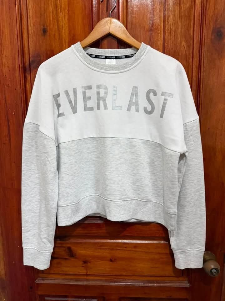 Everlast Grey and White Cropped Sweatshirt (Category: Longsleeves) located in Taguig. Submitted by geestuff27 (Listing ID 1448889220, Image 1). Description: - Grey and white cropped sweatshirt from Everlast - Features the iconic Everlast logo across the chest - Comfortable and casual design - Perfect for everyday wear - Please check the photos for a closer look at the details.