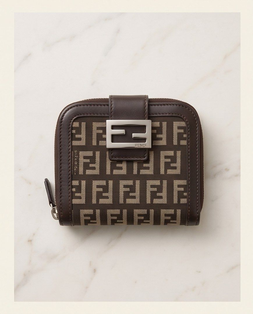 Fendi Zucca Monogram Compact Wallet (Category: Luxury Bags & Wallets) located in Manila. Submitted by goldenriver_777 (Listing ID 1448708755, Image 1). Description: Fendi Classic Zucca canvas with brown leather trim - Bifold style with zip-around coin pocket - Very compact with multiple card slots inside - Silver Fendi logo hardware - Great for everyday use Well used but in good condition Self-authenticated, bought preloved *** photo enhanced by 
