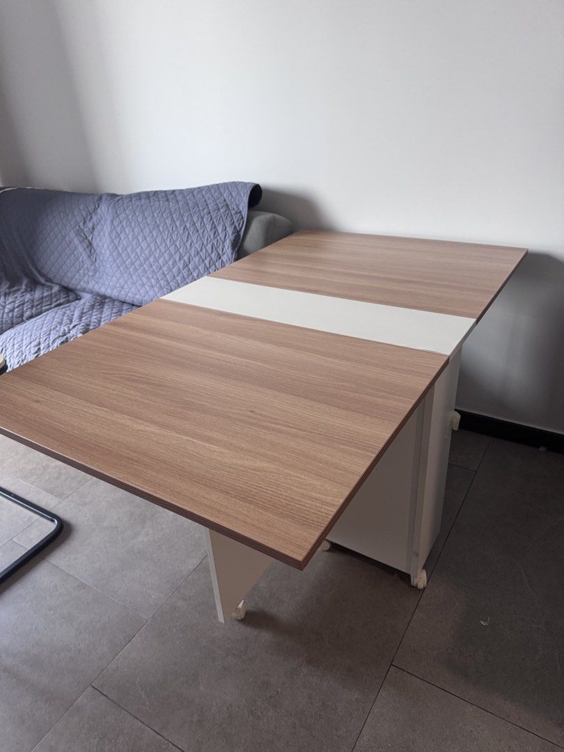 Foldable Dining Table with Wheels (Category: Tables & Sets) located in Singapore. Submitted by ter85ter (Listing ID 1448776921, Image 3). Description: - Compact and foldable design, ideal for small homes. - Versatile use: dining table or extra workspace. - Built-in wheels for effortless mobility. - Folds flat for convenient storage. - Stylish wood grain finish with a clean white top. .