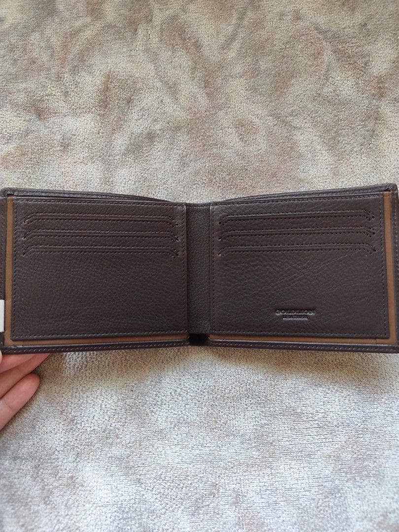 Gold lion Brown Leather Bifold Wallet (Category: Luxury Bags & Wallets) located in Carmona. Submitted by francesantoniette (Listing ID 1448805237, Image 2). Description: - Genuine Givenchy brown leather bifold wallet - Iconic Givenchy logo on the front - Ample card slots for all your essentials - Subtle patterned interior lining - Ideal for everyday carry and style.