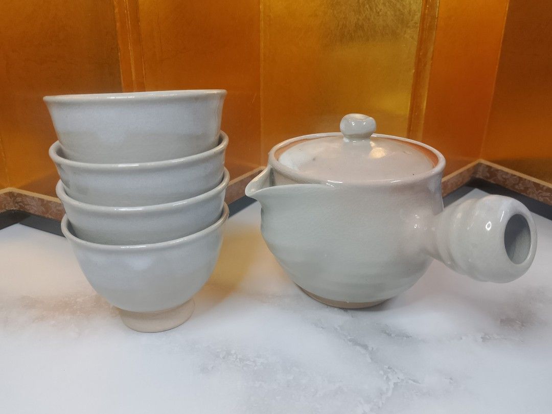Japanese Style Stoneware Teapot and Cups Set (Category: Coffee & Tea Tableware) located in Valenzuela. Submitted by buylaaaaa (Listing ID 1448709366, Image 1). Description: - Beautiful ceramic teapot and 4 matching cups - Light grey glaze with a subtle crackle finish - Comfortable handle and easy-pour spout on teapot - Cups are stackable for convenient storage - Perfect for a calming tea experience - A lovely addition to any kitchen or tea collec