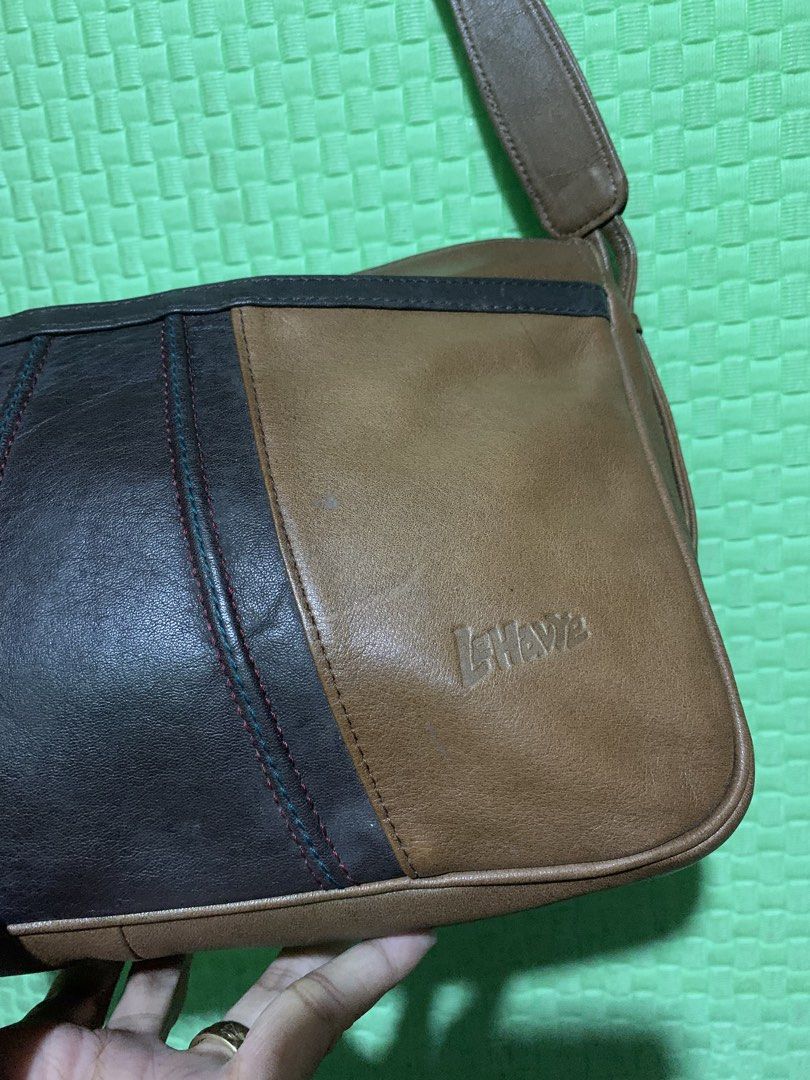 Le Hawa Brown & Black Leather Shoulder Bag (Category: Shoulder Bags) located in Carigara. Submitted by spark2503 (Listing ID 1448718044, Image 2). Description: - Chic brown and black leather shoulder bag - Features a mix of smooth and textured leather panels - Embossed Le Hawa logo on the front - Adjustable strap for comfortable wear - Ideal for everyday use - Shows some signs of wear consistent with age and use.