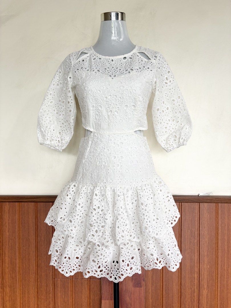Maje White Eyelet Cut-out Ruffle Layer Mini Dress (Category: Dresses) located in Cebu City. Submitted by stylingtrends.coll (Listing ID 1448713385, Image 2). Description: - White eyelet mini dress - Features cut-outs at the waist and shoulders - Puff sleeves with elastic cuffs - Tiered ruffle skirt with scalloped hem - Back zipper closure Size: Small.