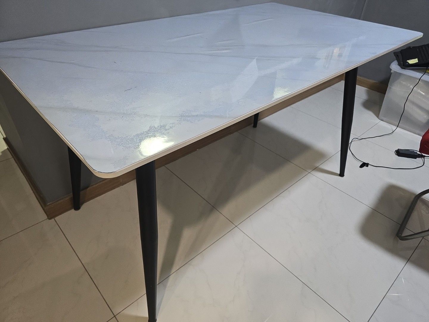 Dining table (Category: Tables & Sets) located in Singapore. Submitted by rider_92 (Listing ID 1448822641, Image 1). Description: - Rectangular dining table - White marble-effect top with subtle veining - Four black tapered legs - Rounded tabletop edges - Suitable for dining area or kitchen - Easy to clean surface no chairs length 1.4m width 1.2.