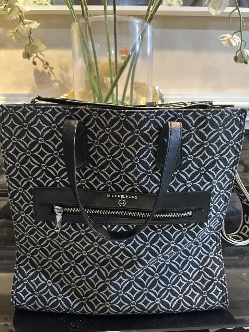 Michael Kors Monogram Tote Bag (Category: Luxury Bags & Wallets) located in Malabon City. Submitted by bda_jewels_clothing (Listing ID 1448888830, Image 1). Description: - Authentic Michael Kors tote bag - Classic black and white MK monogram pattern - Genuine leather trim and handles - Convenient zippered front pocket - Adjustable shoulder strap with signature MK logo - Roomy interior for all your essentials Original Price 28,000 used 4x only dec