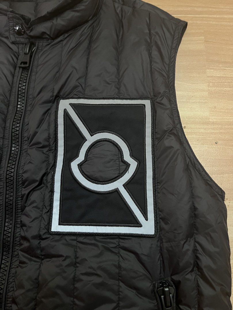 Moncler Black Down Vest with Reflective Detail (Category: Luxury Apparel) located in Victorias. Submitted by lan1877 (Listing ID 1448893364, Image 2). Description: - Moncler black puffer vest - Sleeveless design - Zip-up front closure - Reflective patch on chest - Reflective band at hem - Two side zip pocket - Made in Romania Issue nsa last pics Small pinhole - Down certified Good as new Size medium on tag 22W 27L dimension No issue 1200 plus sf.