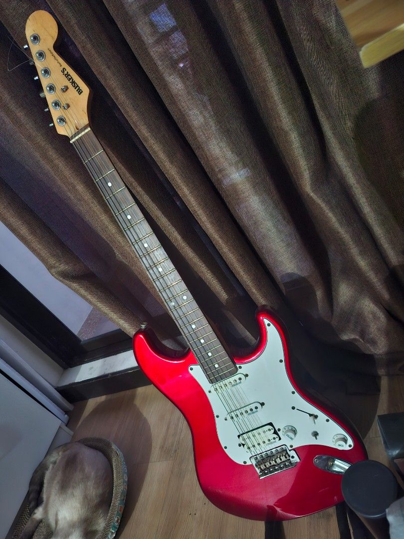 Red Busker's Electric Guitar (Category: Musical Instruments) located in Paranaque City. Submitted by ghanreagan15.1 (Listing ID 1448806273, Image 1). Description: - Red electric guitar - Stratocaster style body - White pickguard - Silver hardware note: slightly rust hardware wilkinson humbucker pickups comes with padded gig bag worth 1.5k guitar stand guitar strap tremolo - 'Busker's' brand on headstock - Ready for a new owner.