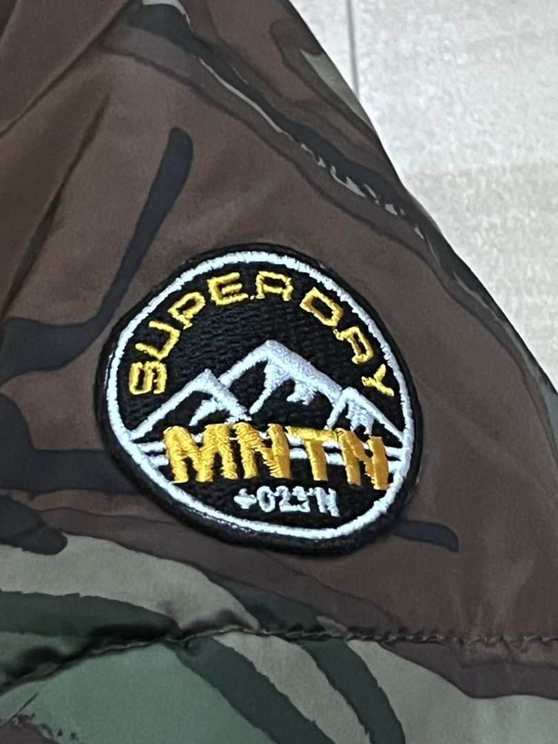 Superdry MNTN Squad Camo Puffer Jacket Yellow Hood (Category: Coats, Jackets and Outerwear) located in Victorias. Submitted by lan1877 (Listing ID 1448891982, Image 3). Description: - Superdry camo puffer jacket - Yellow upper section with sherpa-lined collar - MNTN Squad patch on chest and back - Zipper closure with pockets - Drawstring hem Good as new Size XL on tag 23W 27L dimension Issue missing hood 1800 plus sf - Made in China.