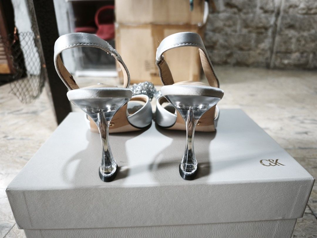 Charles & Keith Silver Slingback Heels with Bow Detail (Category: Heels) located in Manila. Submitted by icee_09 (Listing ID 1448967238, Image 2). Description: - Brand: Charles & Keith - Color: Silver - Style: Slingback heels - Features: Sparkly bow on front, clear block heel - Size: 37 - Condition: Comes with original box RFS: decluttering Shipping from Meycauayan or Makati.