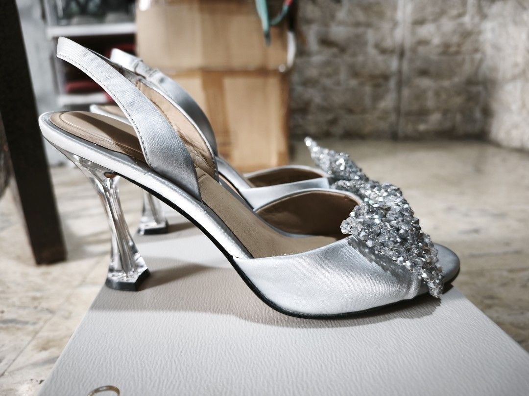 Charles & Keith Silver Slingback Heels with Bow Detail (Category: Heels) located in Manila. Submitted by icee_09 (Listing ID 1448967238, Image 3). Description: - Brand: Charles & Keith - Color: Silver - Style: Slingback heels - Features: Sparkly bow on front, clear block heel - Size: 37 - Condition: Comes with original box RFS: decluttering Shipping from Meycauayan or Makati.
