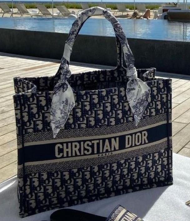 Christian Dior BOOK TOTE Large (Category: Luxury Bags & Wallets) located in San Jose del Monte. Submitted by wendylux (Listing ID 1448480733, Image 1). Description: Model Style: Dior Book Tote Pattern Motif: Blue Dior Oblique Embroidery Design Elements: Front horizontal band displaying the capitalized "CHRISTIAN DIOR" signature. Accessories: Silk scarf/twilly tied into a bow at the base of the handle. good condition.