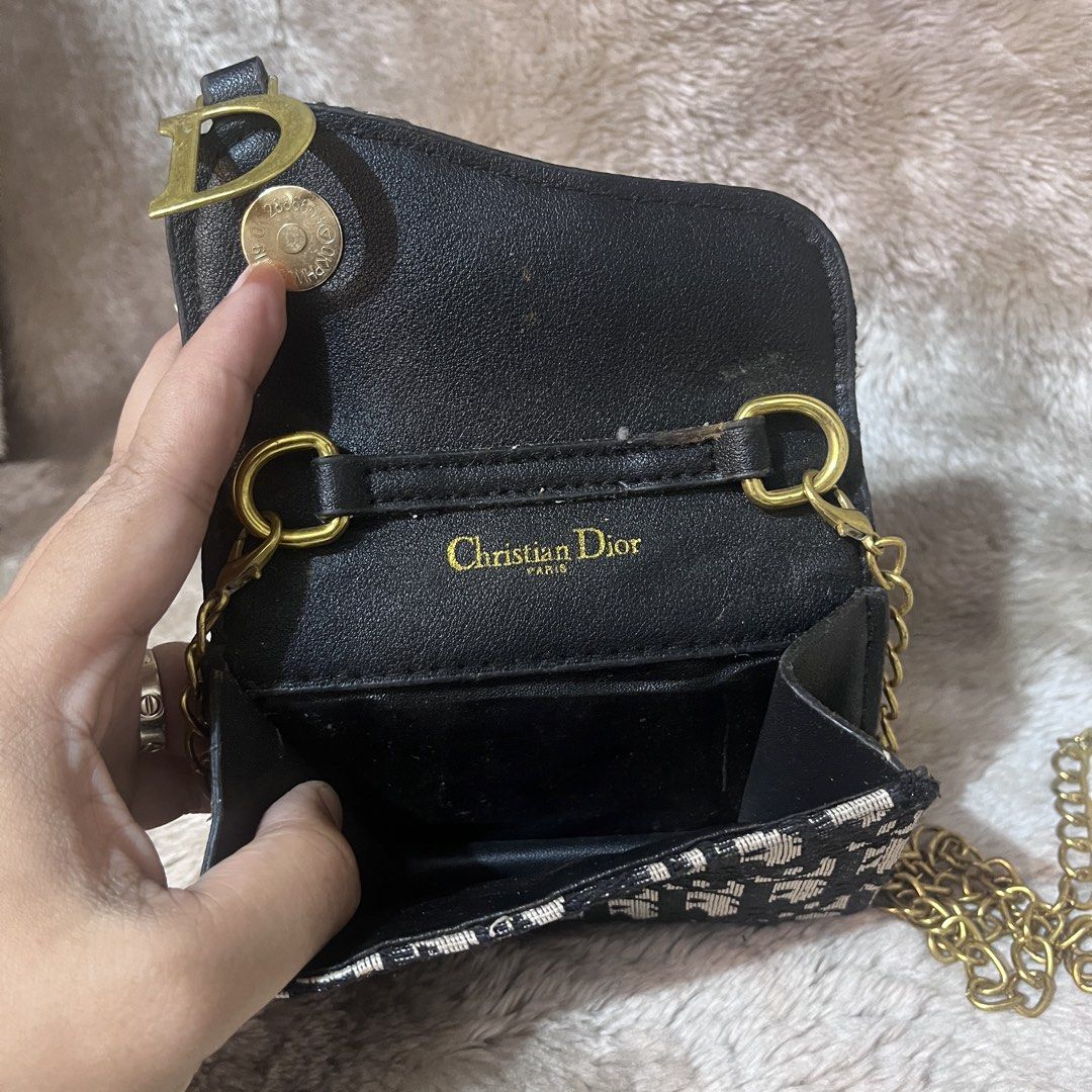 Christian Dior Monogram Wallet with Chain (Category: Wallets & Card holders) located in Cabadbaran. Submitted by dfgthriftology (Listing ID 1448916398, Image 2). Description: - Dior monogram wallet - Features classic Dior pattern - Adorned with a gold 'D' charm - Includes a detachable gold chain strap - Interior with compartments for cards and cash - Small and compact design, perfect for essentials - Shows some signs of wear inside.