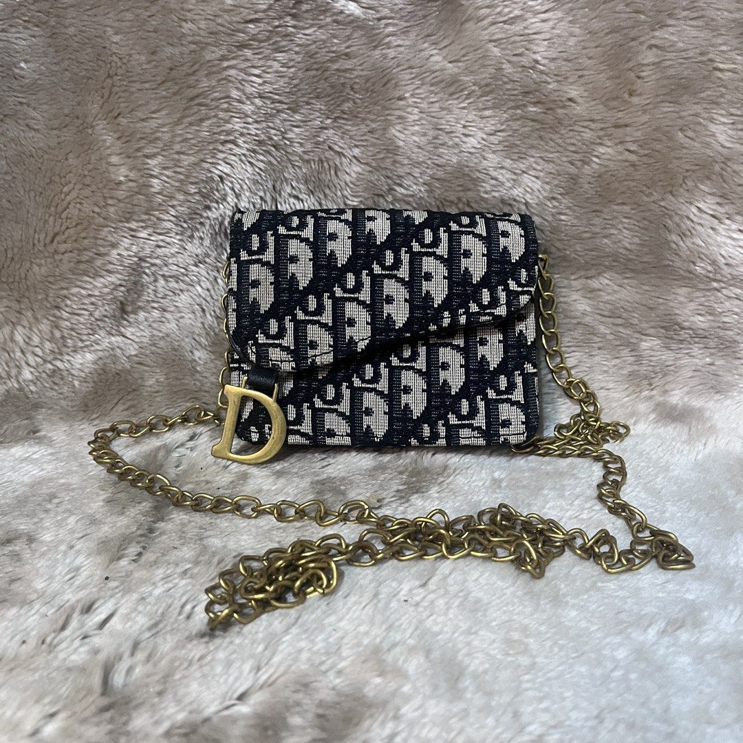 Christian Dior Monogram Wallet with Chain (Category: Wallets & Card holders) located in Cabadbaran. Submitted by dfgthriftology (Listing ID 1448916398, Image 1). Description: - Dior monogram wallet - Features classic Dior pattern - Adorned with a gold 'D' charm - Includes a detachable gold chain strap - Interior with compartments for cards and cash - Small and compact design, perfect for essentials - Shows some signs of wear inside.