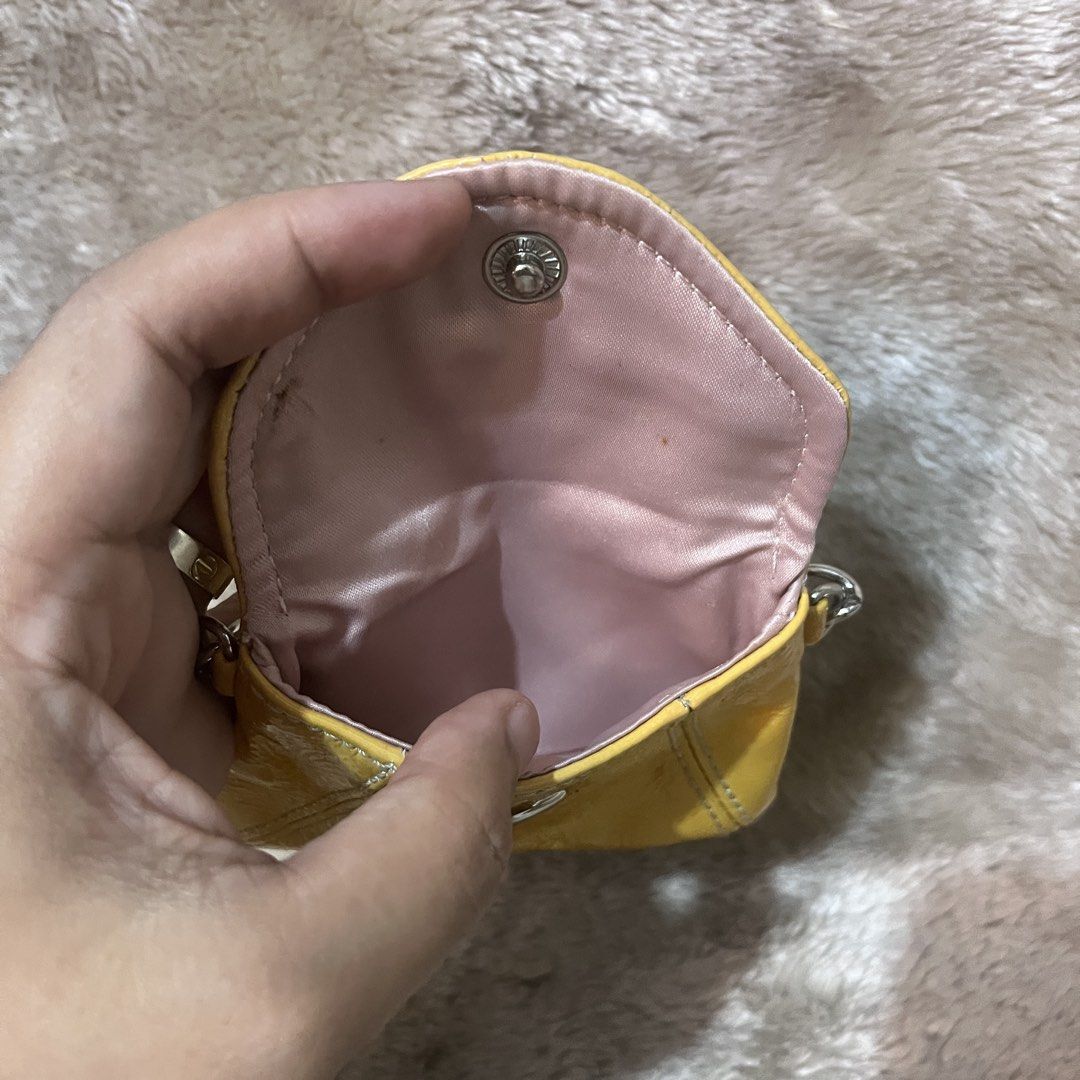 Coach Yellow Leather Coin Pouch with Chain (Category: Purses & Pouches) located in Butuan. Submitted by dfgthriftology2.0 (Listing ID 1448917601, Image 2). Description: - Authentic yellow Coach coin pouch - Genuine leather material - Secure snap closure - Detachable silver chain - Lined with pink satin interior - Minor exterior marks visible in photos - Ideal for organizing small items like coins, cards, or earbuds.