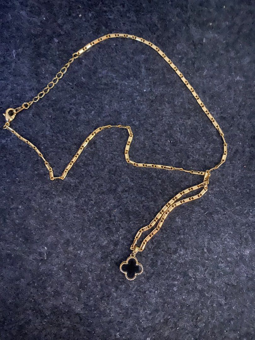 Gold Clover Necklace with Black Charm (Category: Necklaces) located in San Pedro. Submitted by chinitagrace21 (Listing ID 1448997490, Image 1). Description: - Elegant gold chain necklace - Features a stylish black clover charm - Unique rectangular link chain design - Adjustable clasp for customizable length - Perfect for everyday wear or elevating any outfit.