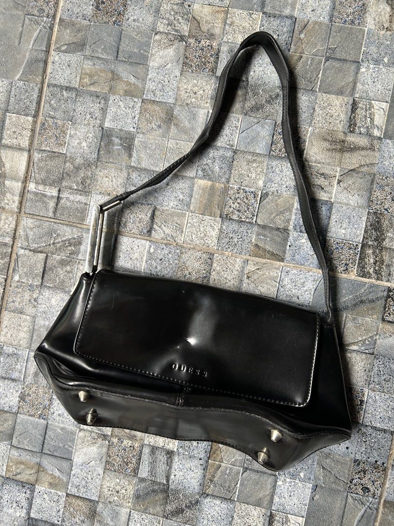 Guess Black Patent leather shoulder bag (Category: Shoulder Bags) located in Quezon City. Submitted by commonwealthpickerph (Listing ID 1448968661, Image 2). Description: Black Guess shoulder bag. - 11 width // 5.5 length - Shiny material. Has the Guess logo on the front flap. - Some small scuffs on the surface. Four metal studs on the bottom. - The strap has metal hardware with the Guess logo. A classic shoulder bag style. - Has sign of used - N