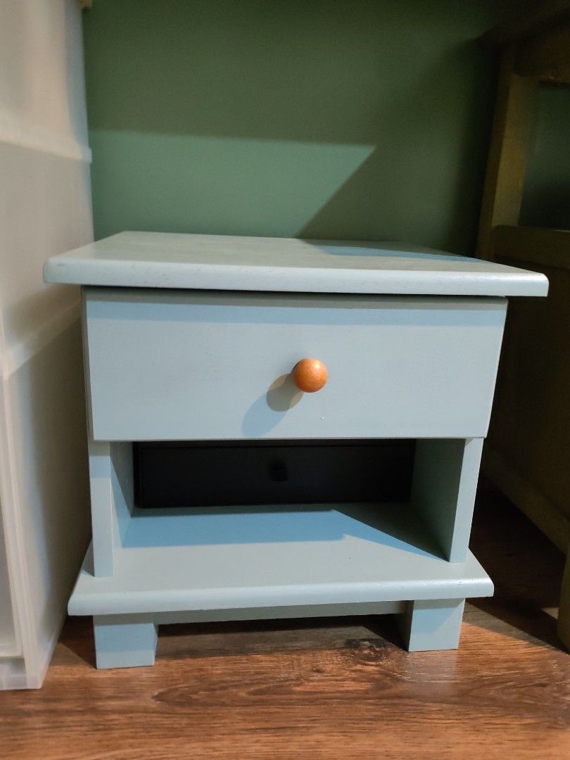 Light Blue Wooden Nightstand with Drawer and Shelf (Category: Shelves, Cabinets & Racks) located in Kuala Lumpur. Submitted by gentlepenguin.6b8aad (Listing ID 1448929911, Image 1). Description: - Light blue wooden nightstand - Features one drawer with a round knob - Includes an open shelf below the drawer - Simple and versatile design - Suitable for bedrooms or living rooms - Approximately 20 inches tall -appro. 15kgs.