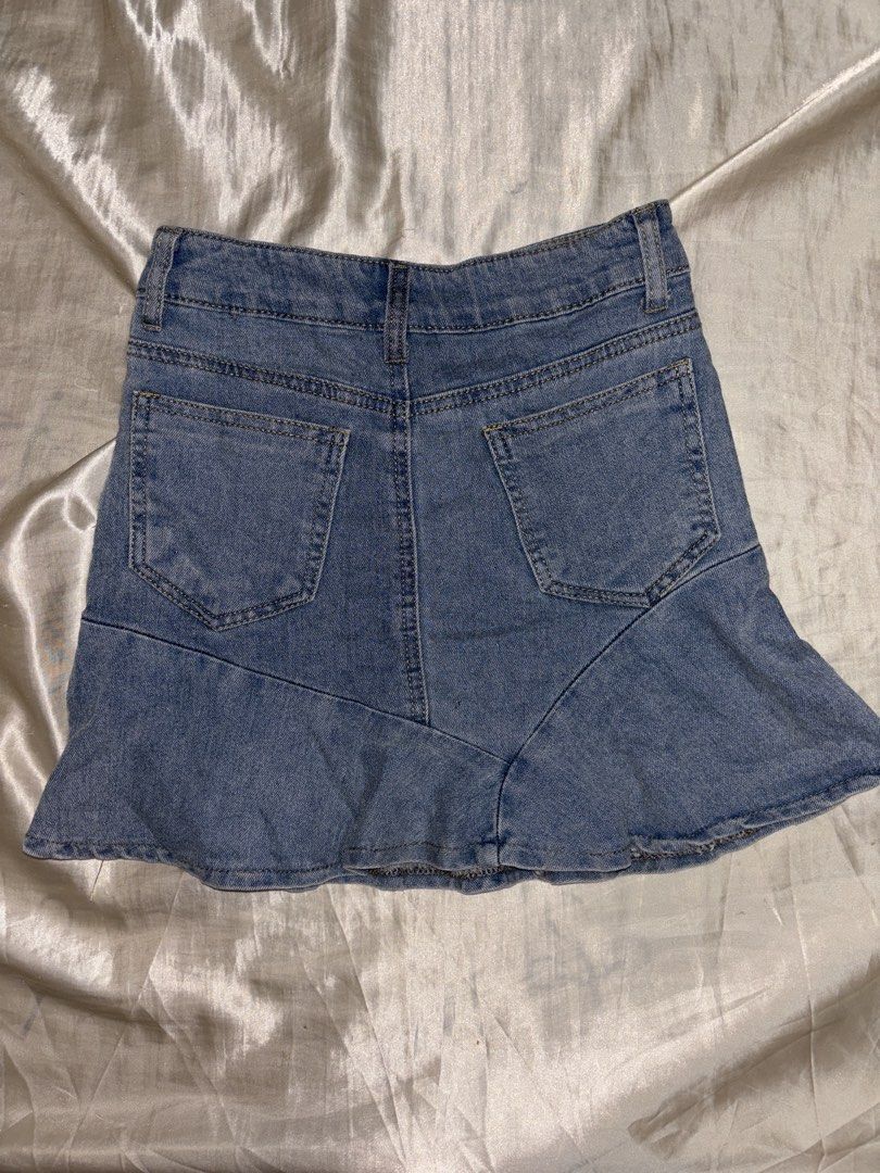 Light Wash Denim Ruffle Skirt Size S (Category: Skirts) located in Muntinlupa City. Submitted by aoki29 (Listing ID 1449098799, Image 2). Description: - Light wash denim skirt - Features a cute ruffle hem detail - Estimated size S - Ideal for casual wear - Versatile and easy to pair with various tops.