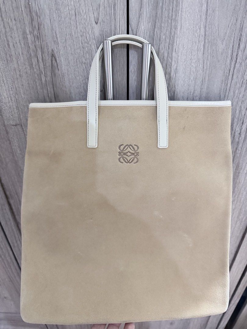 Loewe Suede Tote Bag (Category: Luxury Bags & Wallets) located in Manila. Submitted by vra.luxe (Listing ID 1449019841, Image 1). Description: Inclusions: Dustbag - Authentic Loewe tote bag - Beige suede exterior - White leather trim and interior - Classic Loewe anagram logo embossed on front - Secure magnetic snap closure - Simple and chic design - Ideal for everyday use - Minor Stain Please check or request for more photos. What you see is what