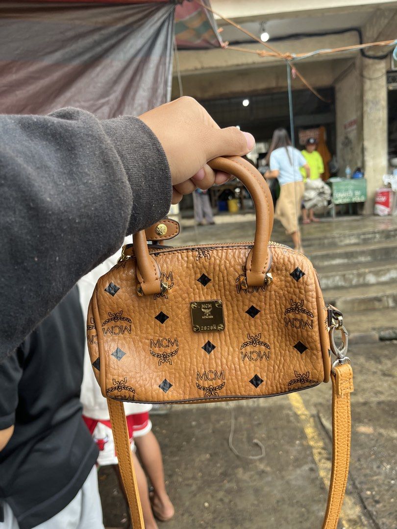 MCM Monogram Mini Boston Bag (Category: Luxury Bags & Wallets) located in Pontevedra. Submitted by thrift01 (Listing ID 1448943506, Image 2). Description: - Cute MCM mini Boston bag - Classic all-over monogram print - Detachable strap for shoulder or crossbody wear - Elegant gold hardware details - Interior tag indicates 'Made in Korea' - Ideal for carrying your daily essentials.