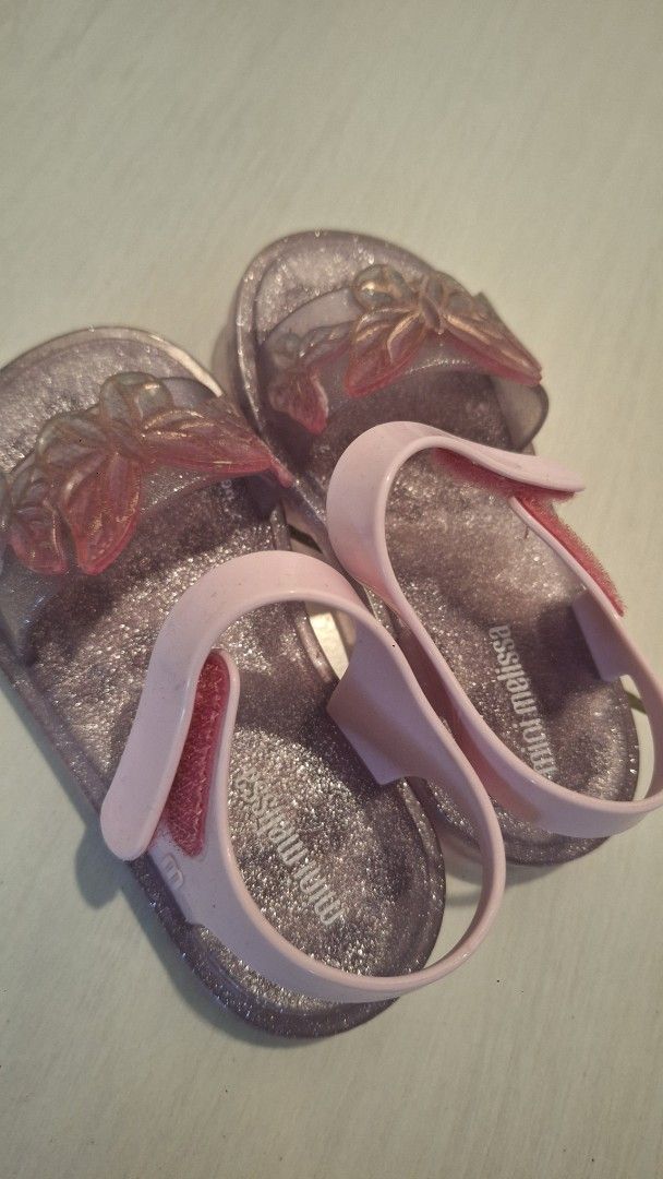 Mini Melissa Glitter Butterfly Jelly Sandals (Category: Babies & Kids Fashion) located in Manila. Submitted by katrinepet63113 (Listing ID 1448898736, Image 1). Description: - Cute Mini Melissa jelly sandals for kids - Features sparkly glitter and butterfly details - Pink straps with easy velcro closure - Durable soles with good grip - Perfect for playtime and everyday wear.