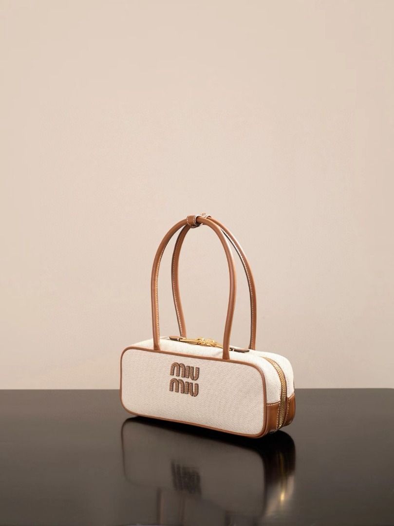 Miu Miu Canvas & Leather Boston Bag (Category: Luxury Bags & Wallets) located in Pateros City. Submitted by rmzekolora80602 (Listing ID 1448918109, Image 3). Description: - Cream canvas with brown leather trim - Classic Miu Miu logo on the front - Secure zipper closure - Comfortable top handles - Chic and versatile design - Ideal for daily use.
