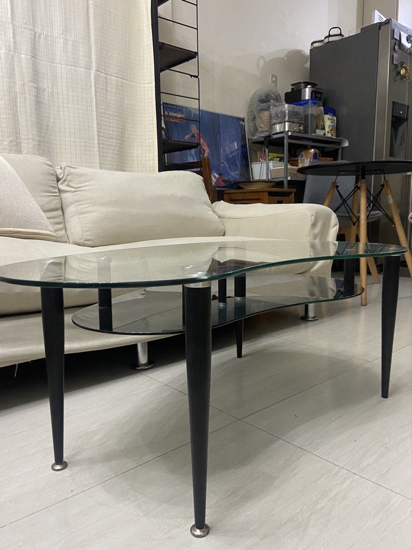 Modern Kidney Bean Glass Coffee Table with Black Base (Category: Tables & Sets) located in Quezon City. Submitted by elektra0111 (Listing ID 1448953503, Image 2). Description: - Unique kidney bean shaped coffee table - Clear tempered glass top - Black lower shelf (minor scuffs) - Black legs with silver accents - Perfect for living rooms or lounges - Adds a modern touch to your space.