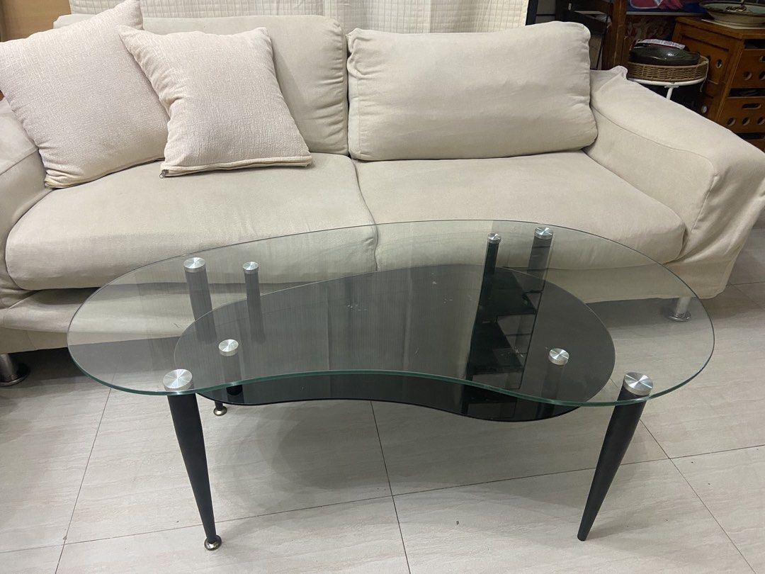 Modern Kidney Bean Glass Coffee Table with Black Base (Category: Tables & Sets) located in Quezon City. Submitted by elektra0111 (Listing ID 1448953503, Image 3). Description: - Unique kidney bean shaped coffee table - Clear tempered glass top - Black lower shelf (minor scuffs) - Black legs with silver accents - Perfect for living rooms or lounges - Adds a modern touch to your space.