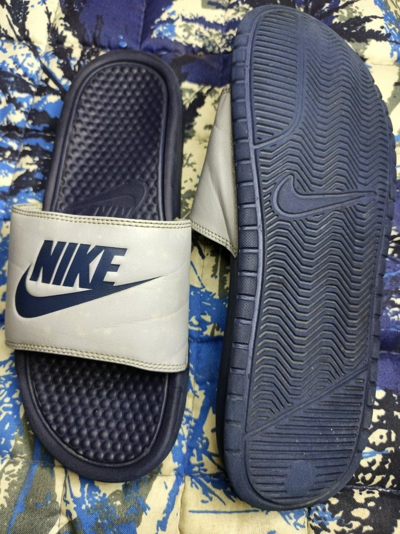 Nike Benassi JDI Slides Navy Blue White (Category: Slippers & Slides) located in Aloran. Submitted by ryban91 (Listing ID 1448889737, Image 2). Description: - Classic Nike slides - Navy blue base with white strap - Iconic Nike swoosh logo - Comfortable for everyday wear or post-sports - Easy slip-on design - Ideal for gym or casual outings.
