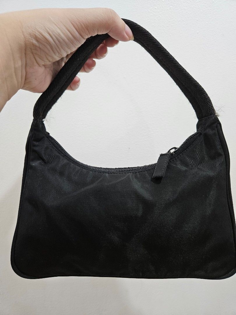 Prada Hobo Nylon Bag Black (Category: Luxury Bags & Wallets) located in Makati City. Submitted by ashasluxurycloset (Listing ID 1448935727, Image 2). Description: - Authentic Prada hobo shoulder bag - Made from durable black nylon - Features the iconic Prada triangle logo - Secure zipper closure - Stylish herringbone textured strap - Ideal for everyday use - A classic and timeless Prada piece.