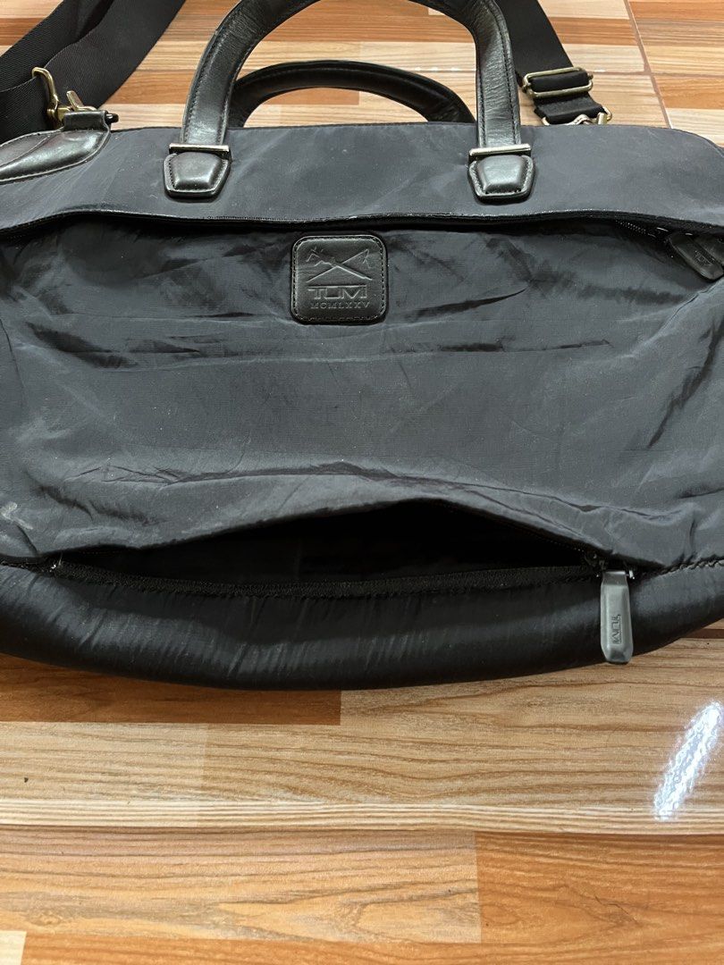 Tumi Black Nylon Leather Briefcase Laptop Bag (Category: Briefcases) located in Nabua. Submitted by lastthrift2.0 (Listing ID 1449017935, Image 3). Description: - Brand: Tumi - Color: Black - Material: Nylon with leather accents - Features: Detachable shoulder strap, spacious main compartment, front zip pocket for quick access - Ideal for: Work, travel, carrying laptops and essentials - Condition: Good, with some signs of wear.