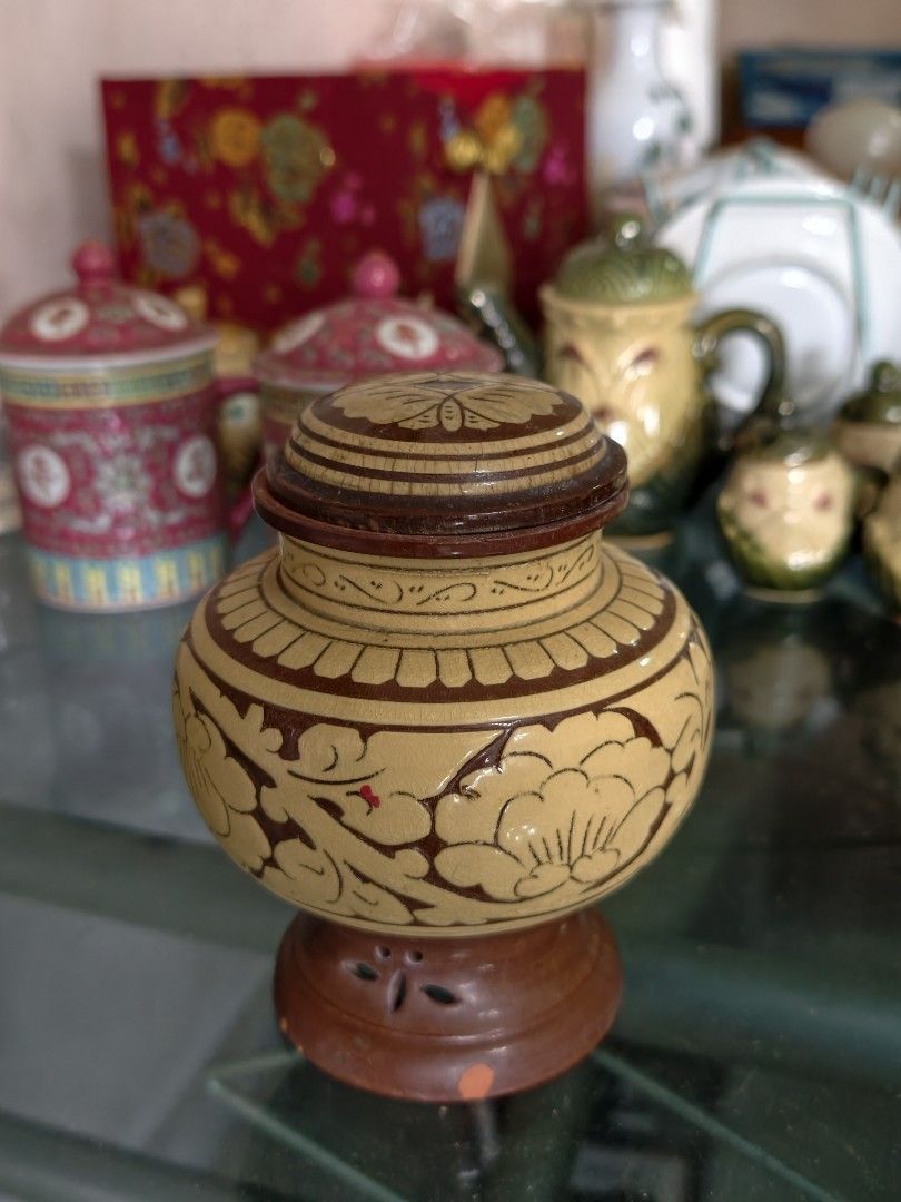 Vintage Wooden Jar with Lid and Stand (Category: Vases & Decorative Bowls) located in Puchong. Submitted by briandeal (Listing ID 1449018518, Image 1). Description: - Intricately carved small wooden jar - Includes matching lid and decorative stand - Light yellow wood with dark brown painted details - Approximately 15cm tall (with lid) - Ideal for display or storing small trinkets.