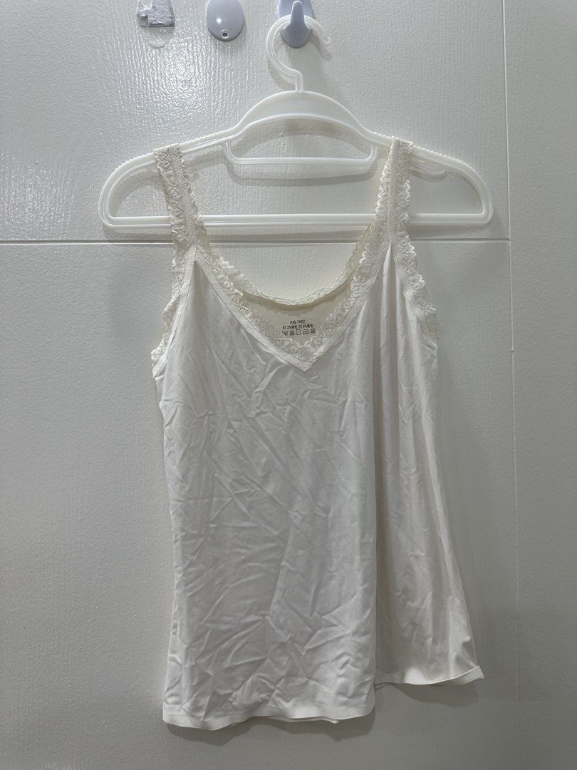 White Lace Trim Camisole Top (Category: Sleeveless) located in Quezon City. Submitted by _cc_declutters (Listing ID 1449080825, Image 1). Description: - Classic white camisole - Delicate lace trim along neckline - Thin adjustable straps - Versatile for layering or standalone wear - Ideal for everyday outfits.